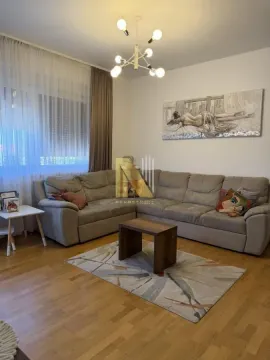 Dnevna soba sa ugaonom garniturom, stočićem i umetničkom slikom na zidu. - image 3