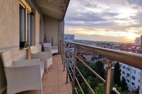 Long covered balcony with outdoor seating and a city view. - image 3