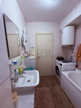 Smaller bathroom with a sink, bathtub, and washing machine. - image 10