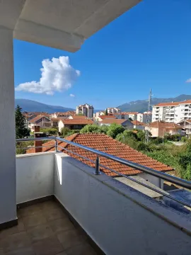 Balkon sa metalnom ogradom i pogledom na naselje i okolne planine. - image 3