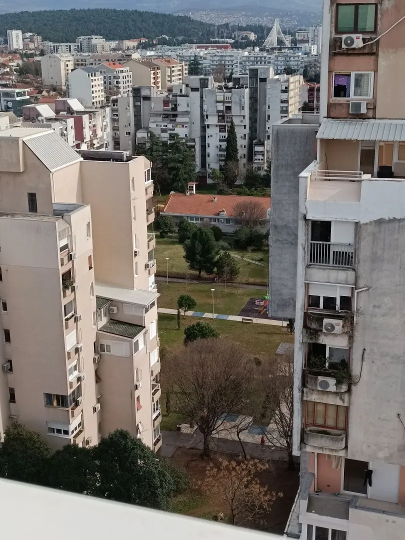 Pogled sa terase na gradske zgrade i zelenilo.