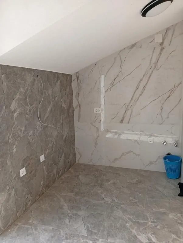 Kuhinja u pripremi sa keramičkim pločicama na zidovima i podu i priključcima za aparate.