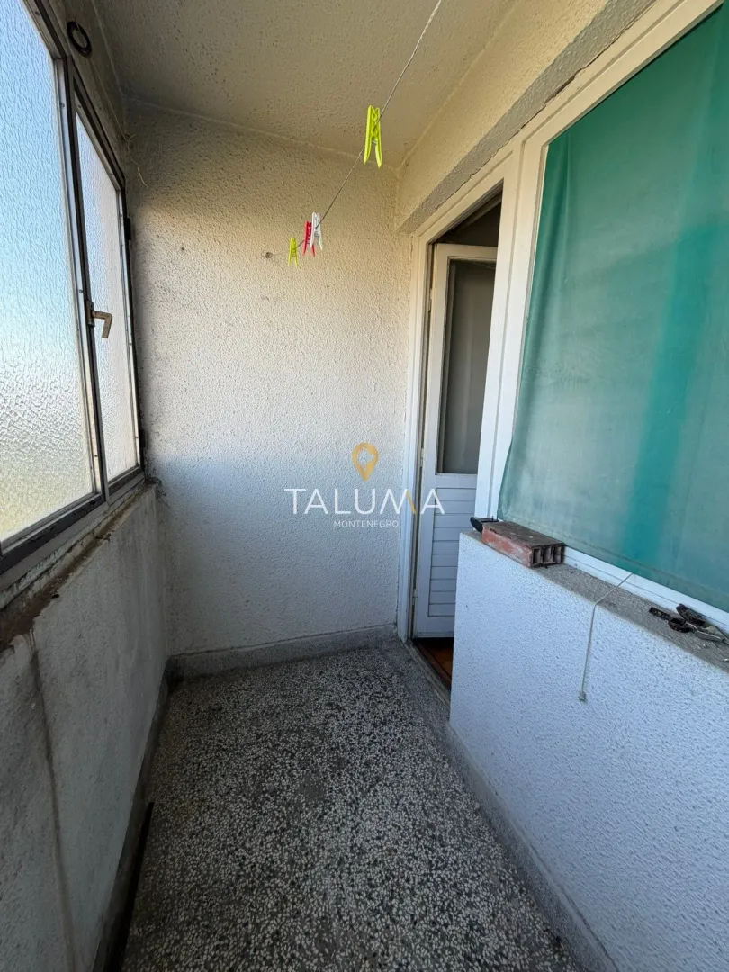 Zastakljeni balkon sa prozorima i vratima koja vode u unutrašnjost stana.