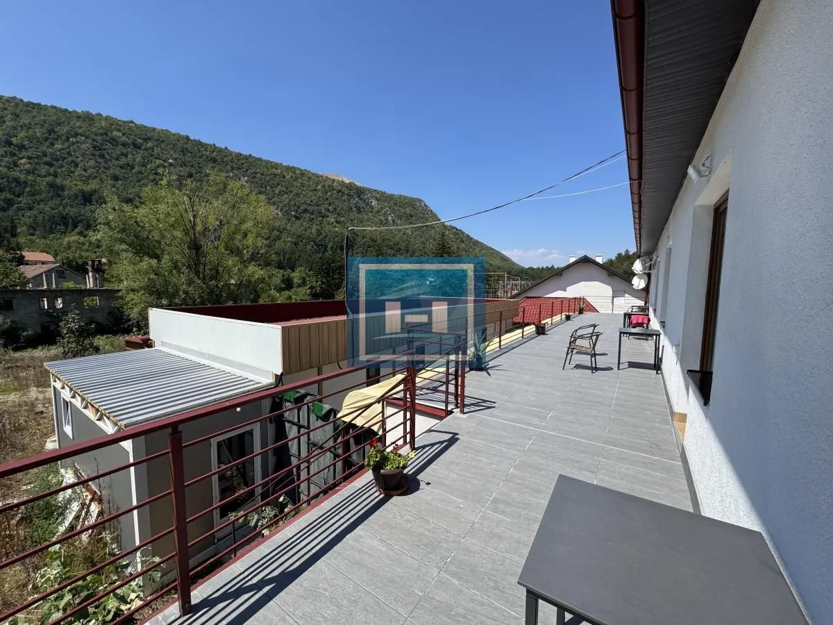 Large tiled terrace overlooking the surrounding mountains and nature.