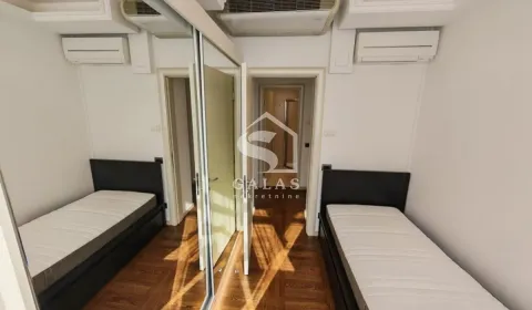 Small bedroom with two single beds and a built-in mirrored wardrobe. - image 9