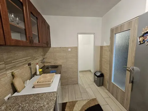 Kuhinja sa drvenim elementima, sudoperom i popločanim zidovima. - image 8