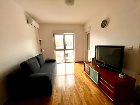 Dnevna soba sa garniturom, televizorom i drvenim podom. - image 2