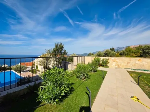 View from the landscaped terrace towards the yard, swimming pool and the sea. - image 14