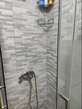 Modern shower cabin with grey tiles and chrome fixtures. - image 4
