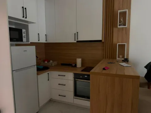 Small kitchen with white cabinets, wooden countertops and built-in appliances. - image 5