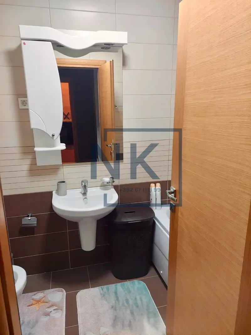 Bathroom equipped with a washbasin, mirror, and toilet.