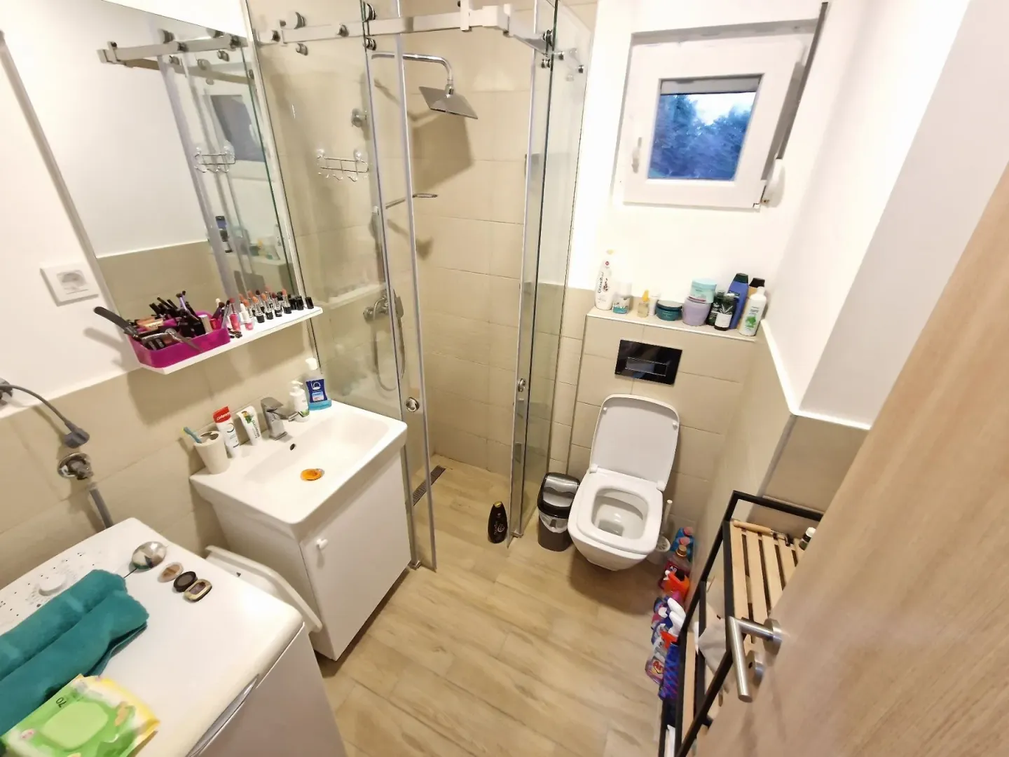 Compact bathroom with a shower cabin, washbasin, and toilet.