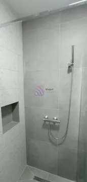 Modern shower enclosure with grey tiles and a built-in niche. - image 2