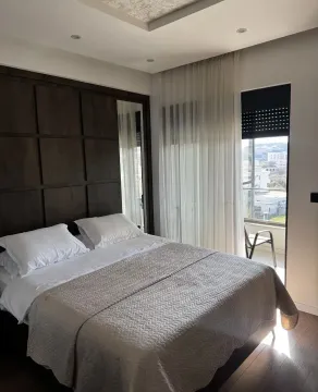 Modern bedroom with a double bed, dark wooden panel, and terrace access. - image 6