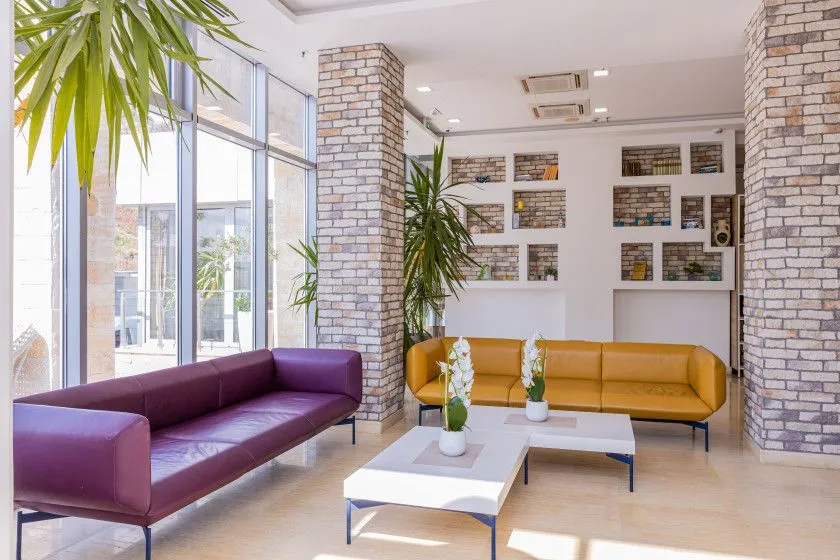 Spacious living room with sofa set and large windows.