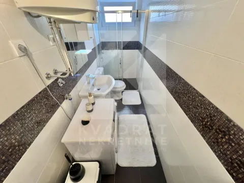 Bathroom equipped with a washbasin, toilet, shower enclosure, and washing machine. - image 7