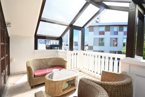 Enclosed terrace with seating furniture and city view. - image 21