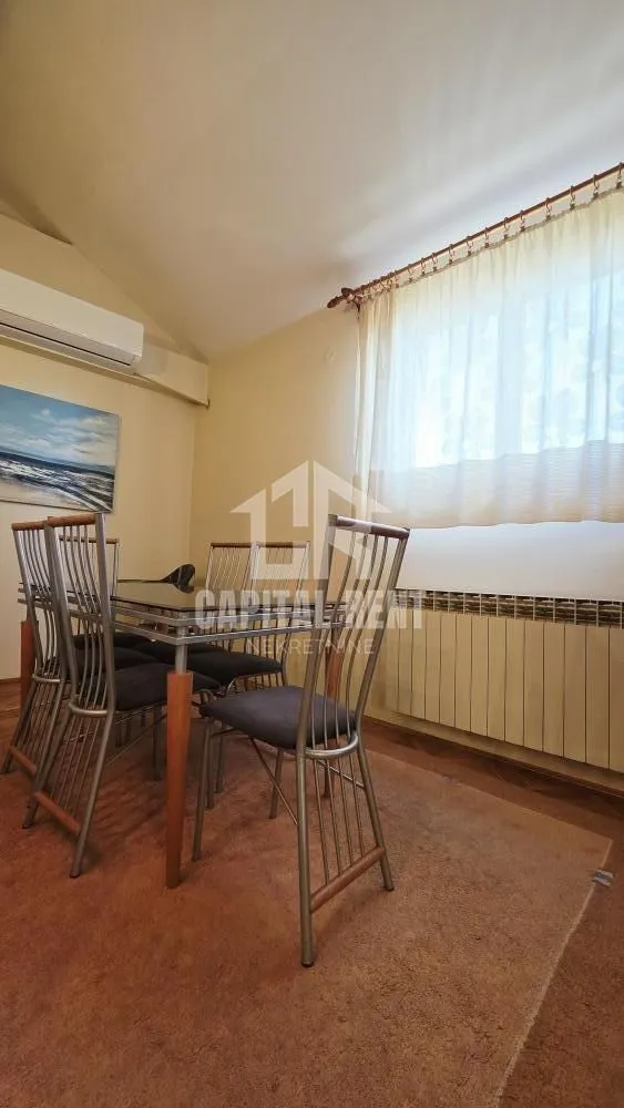 Trpezarija sa stolom, stolicama i prozorom.