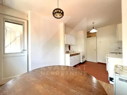 Kuhinja sa trpezarijskim stolom i bijelim elementima. - image 4