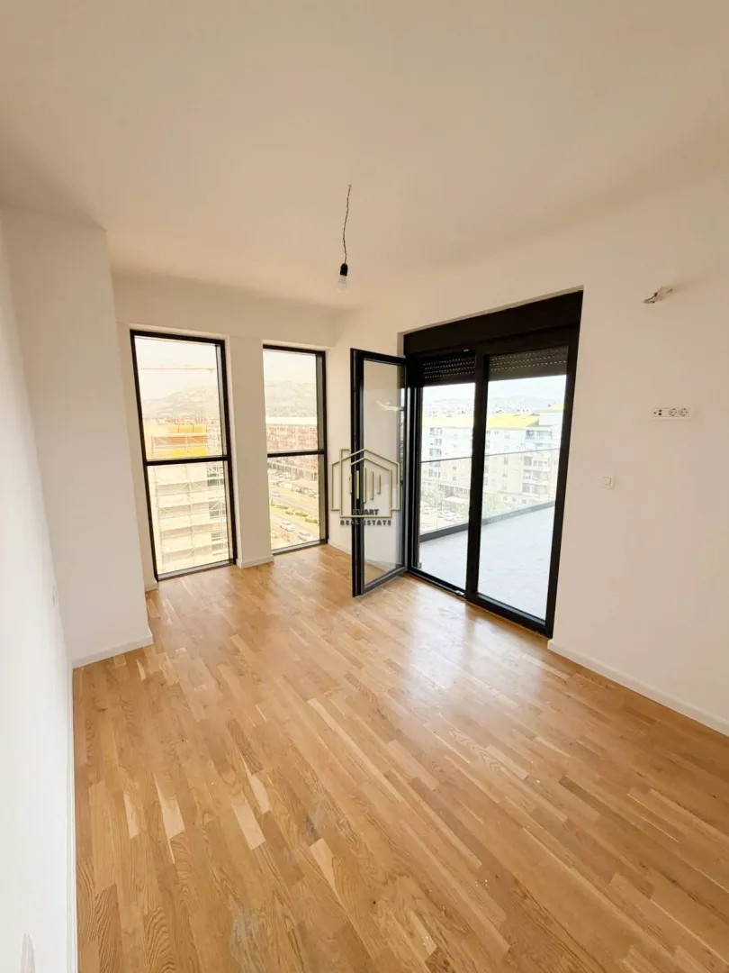 Empty bright room with hardwood flooring and access to the terrace.