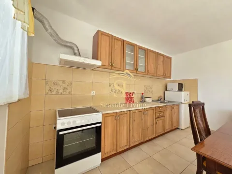 Small kitchen with wooden cabinetry and a built-in stove. - image 7