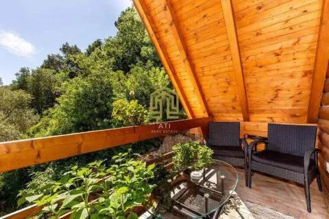 Wooden terrace with seating furniture and a view of greenery. - image 16