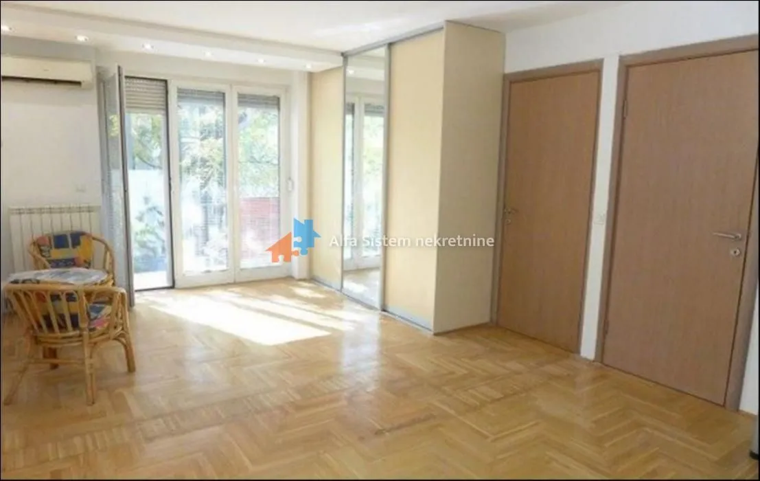 Living room with parquet flooring, built-in wardrobe, and access to the terrace.