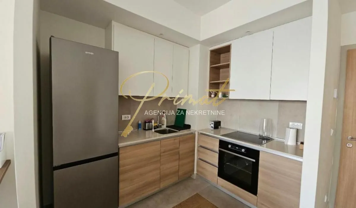 Kitchen equipped with wooden base cabinets and white upper cabinets.