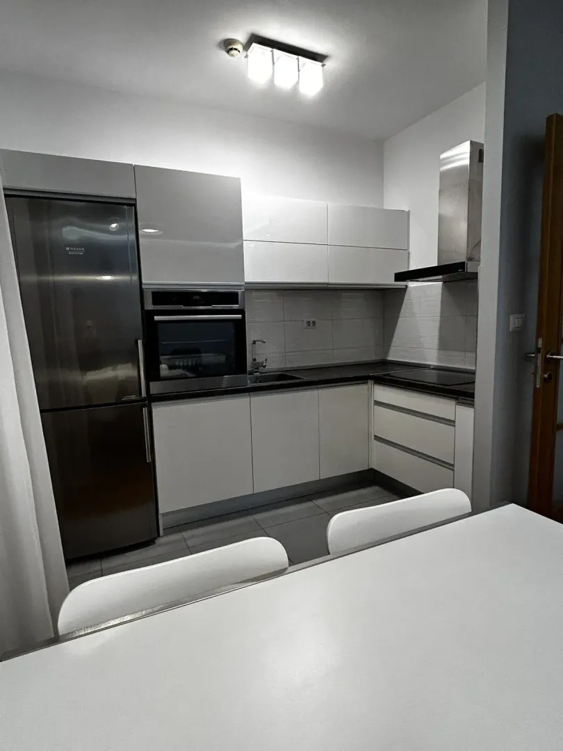 Modern kitchen with white cabinets and built-in appliances.
