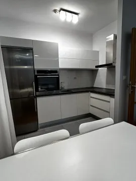 Modern kitchen with white cabinets and built-in appliances. - image 4