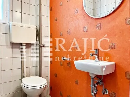 Smaller bathroom with a sink, mirror, and toilet.