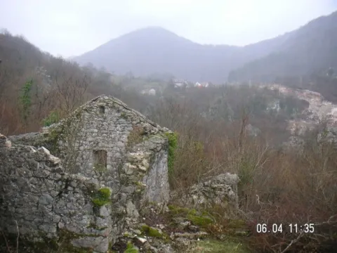 Ruševna kamena kuća u prirodnom okruženju sa pogledom na brda. - image 9