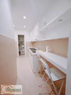 Modern white kitchen with a bar and stools. - image 12