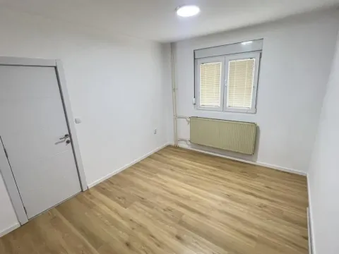 Prazna svetla soba sa laminatom i belim zidovima. - image 7