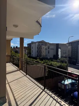 Prostrana natkrivena terasa sa pogledom na ulicu i okolne zgrade. - image 15