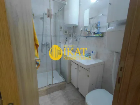 Small bathroom with a shower cabin, washbasin, and toilet. - image 12