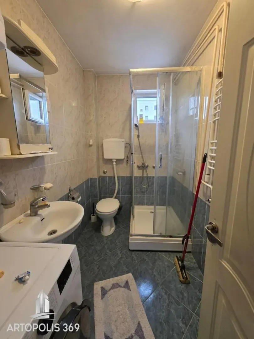 Manje kupatilo sa tuš kabinom, umivaonikom i wc šoljom.