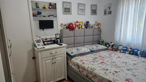 Namještena spavaća soba sa bračnim krevetom, bijelom komodom i ukrasnim detaljima. - image 7