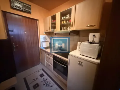 Smaller kitchen with wooden cabinets, a stove, and a refrigerator. - image 4