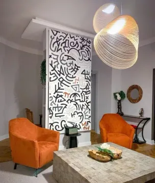 Moderan dnevni boravak sa narandžastim foteljama, ukrasnim panoom i modernim lusterom. - image 10