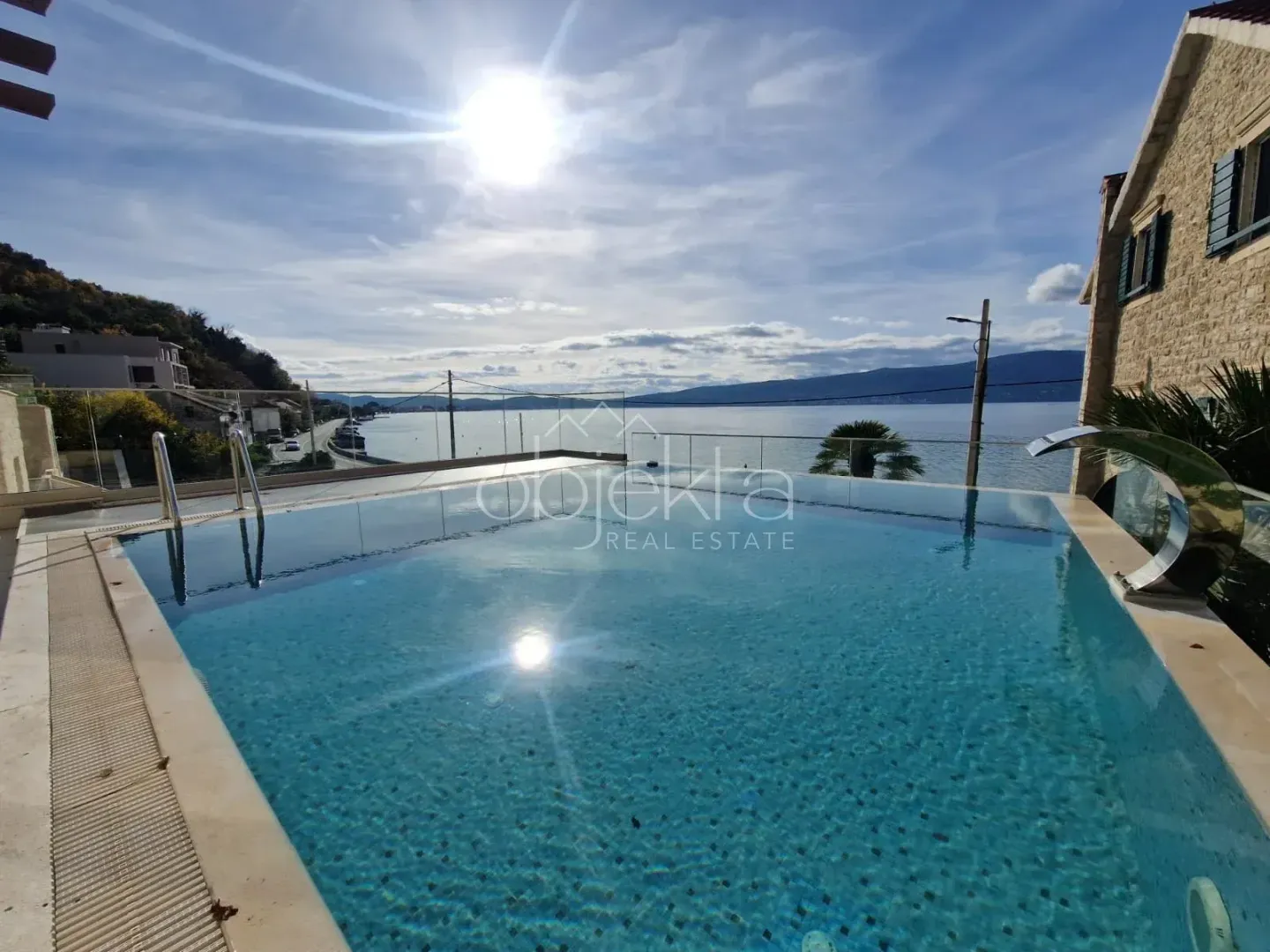 Swimming pool with a view of the sea and part of the house.