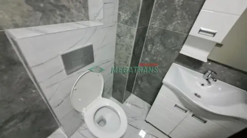 Savremeno opremljeno kupatilo sa umivaonikom, toaletom i zidnim pločicama. - image 6