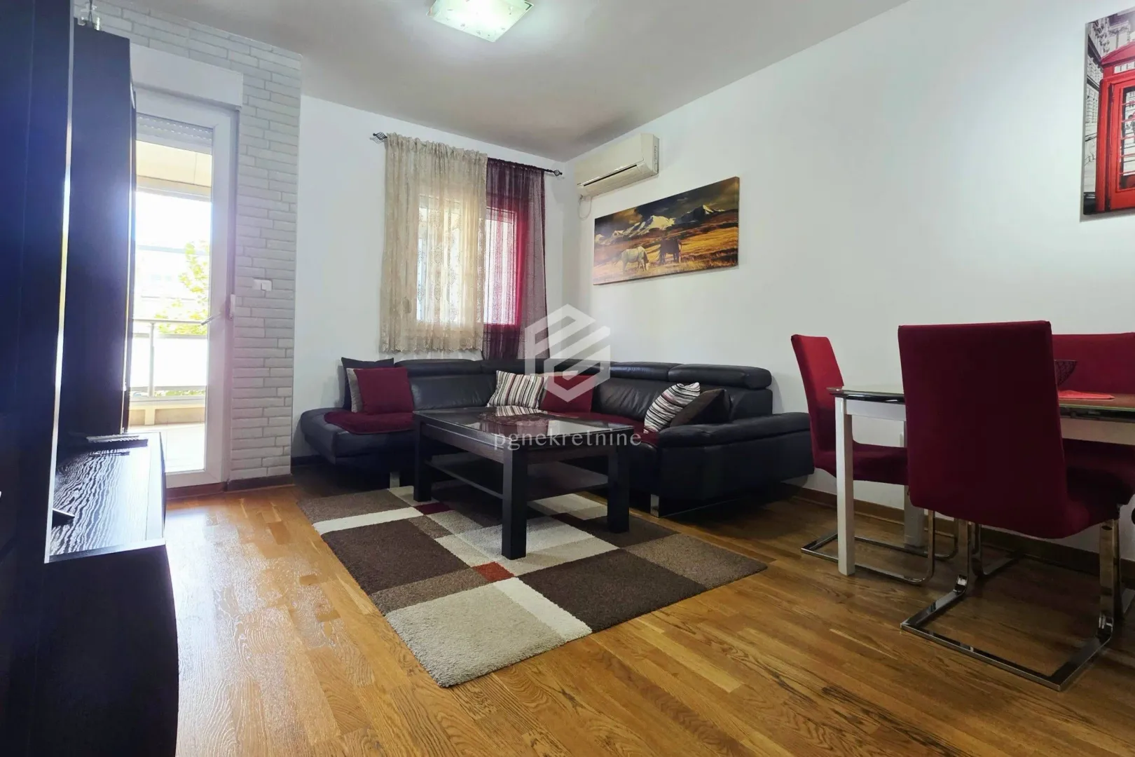 Living room with sofa set, dining table and access to the terrace.