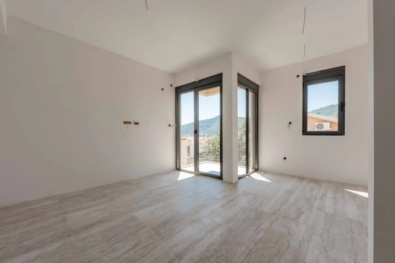 Empty bright room with ceramic tiled floor and access to the terrace.