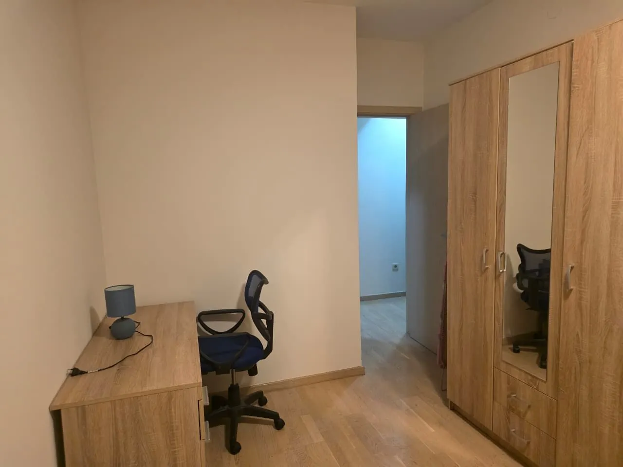 Smaller bedroom with a desk and a wooden wardrobe.