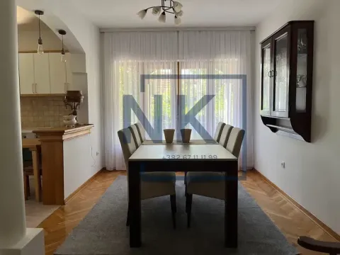 Trpezarija sa stolom i stolicama, povezana sa kuhinjom u pozadini. - image 16