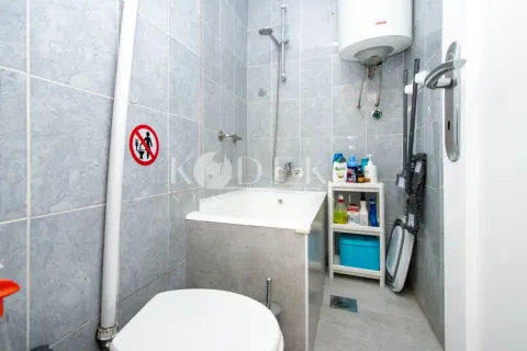 Manje kupatilo sa kadom, toaletom i policom za sredstva za higijenu. - image 9
