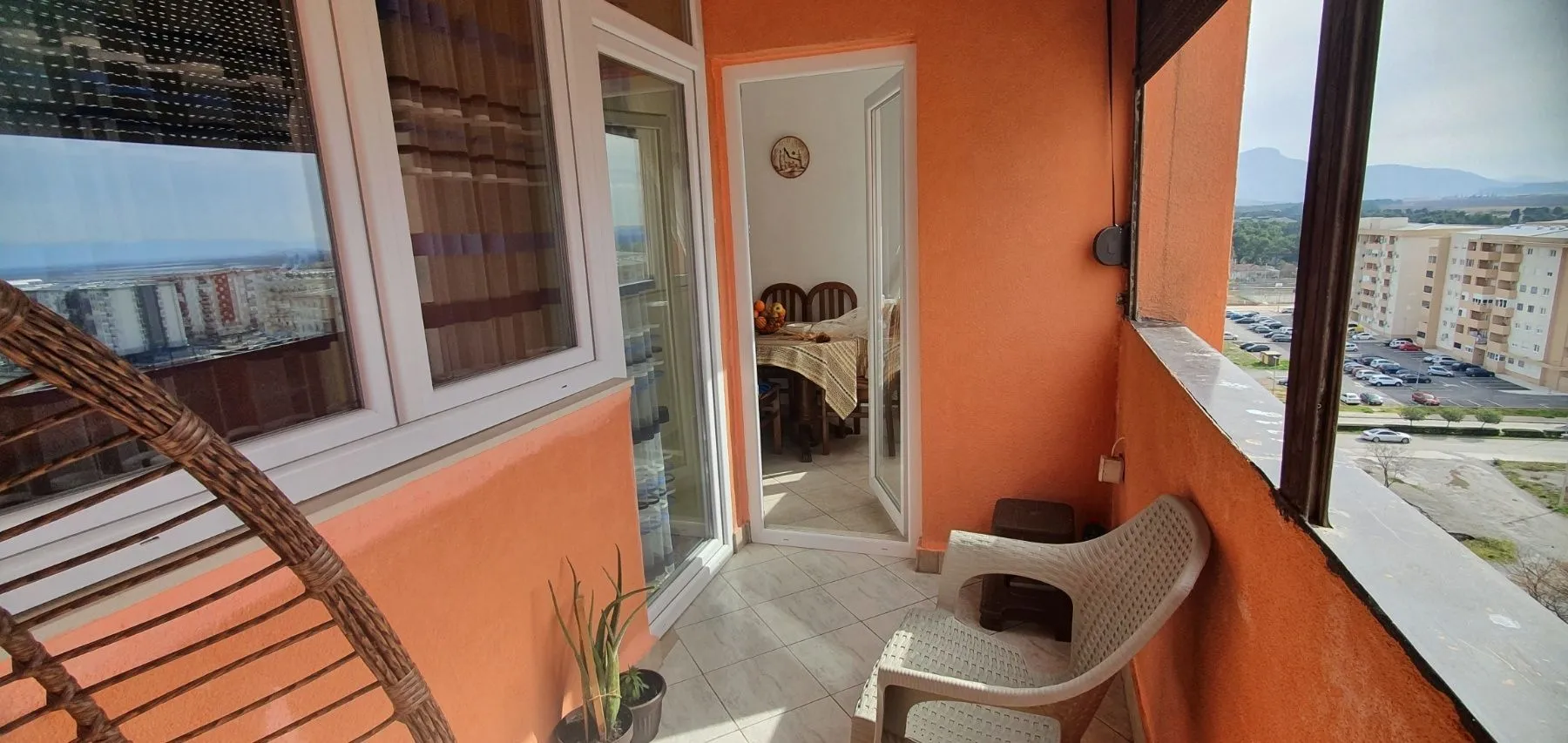 Balkon sa narandžastim zidovima i pogledom na grad.