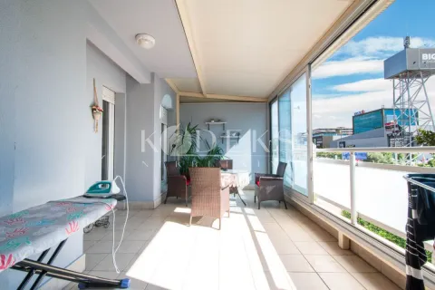 Enclosed balcony with seating furniture and city view. - image 11