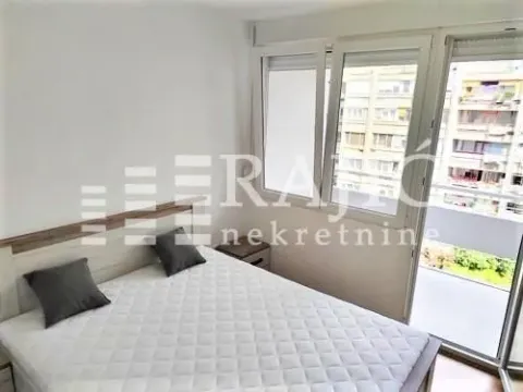 Bright bedroom with a double bed and balcony access. - image 8
